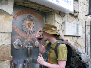 Pilgrim drinking a glass of wine at the fountain of Bodegas Irache doing the Saint James Way