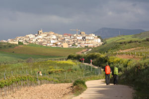 Two pilgrims doing the Saint James Way arriving at Cirauqui